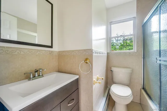 a bathroom with a toilet sink and mirror