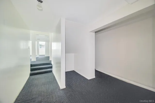 a view of a hallway with wooden floor and a bathroom