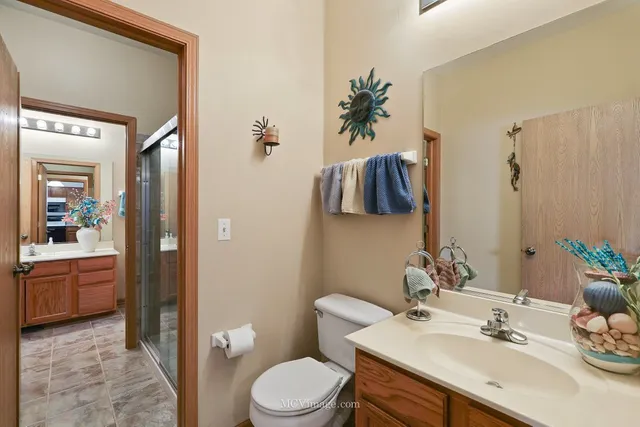 a bathroom with a sink vanity granite and toilet