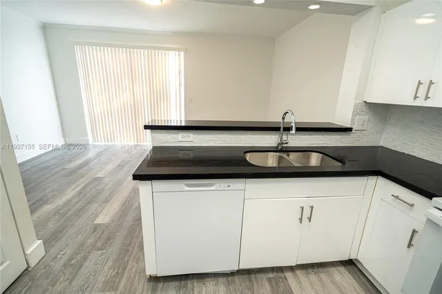 a kitchen with a sink cabinets and wooden floor