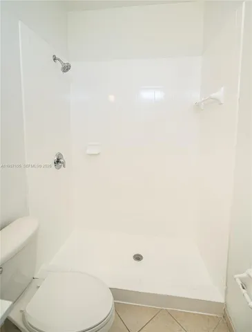 a white toilet sitting next to a bath tub