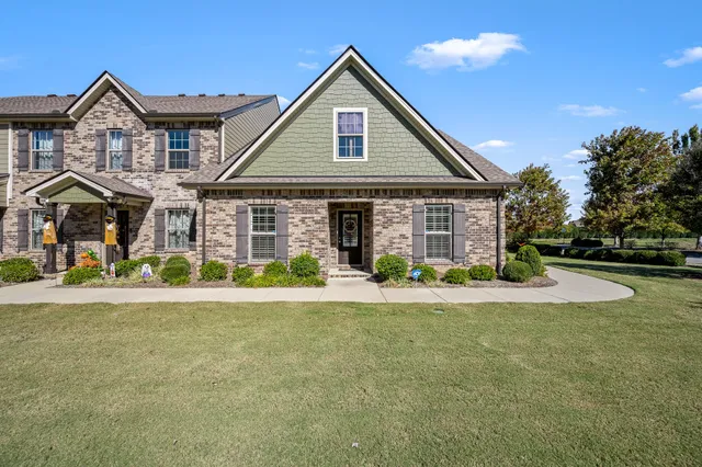 a front view of a house with yard and green space