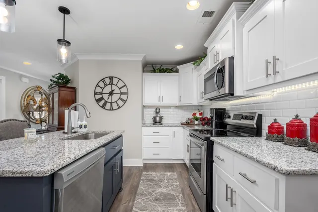 a kitchen with stainless steel appliances granite countertop a stove and cabinets