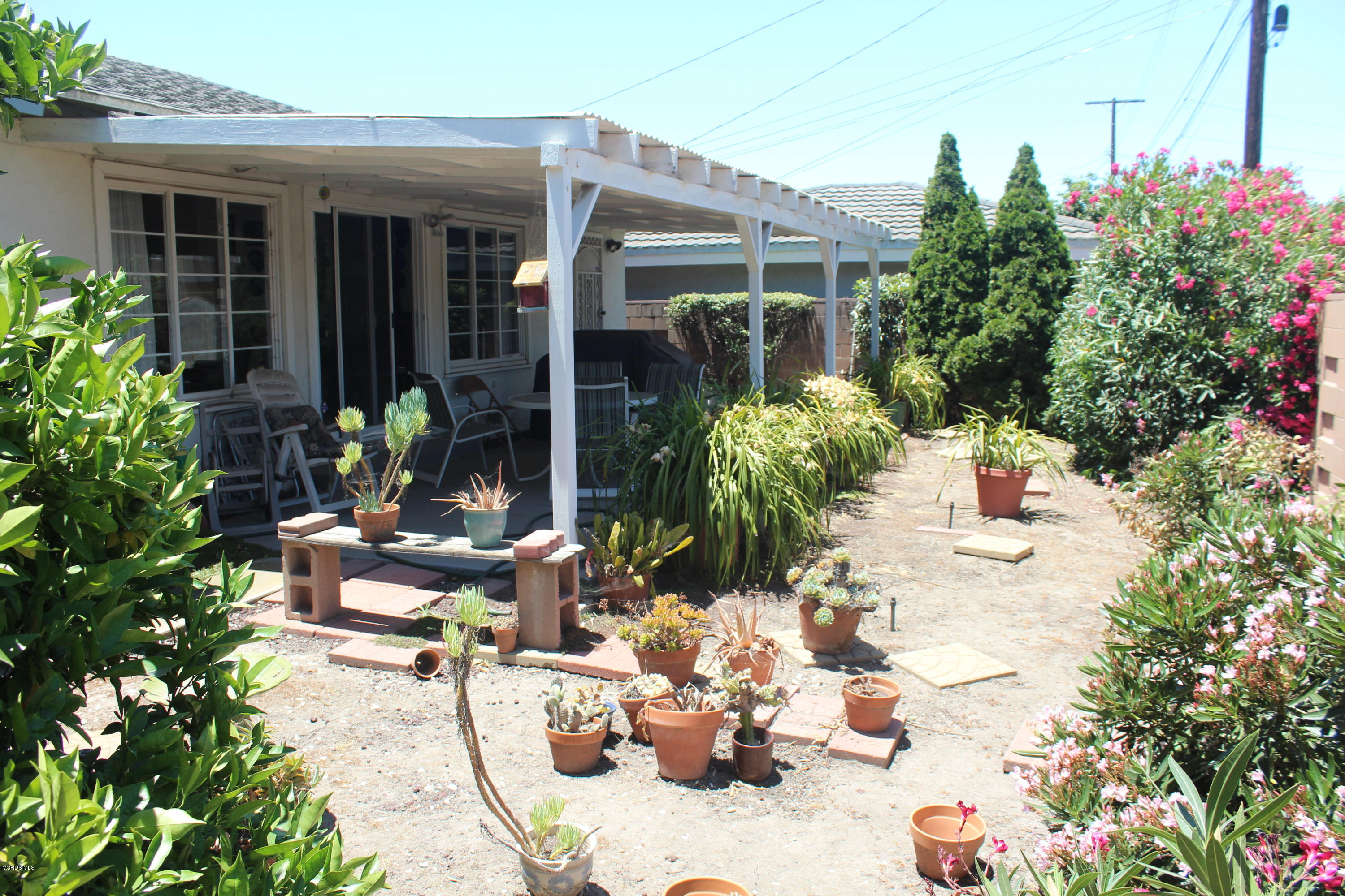 1219 West Roderick Avenue Oxnard, CA 93030 - Photo 15 of 15 a view of a chair and tables in the patio in front of a house