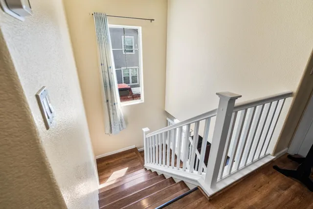 a view of a hallway with wooden floor and staircase