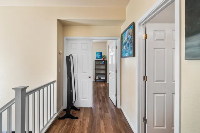 a view of a hallway with wooden floor and staircase