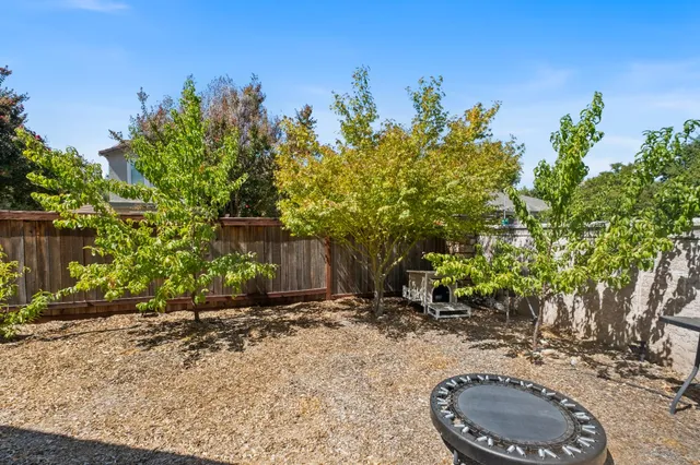 a view of a house with a small yard and wooden fence