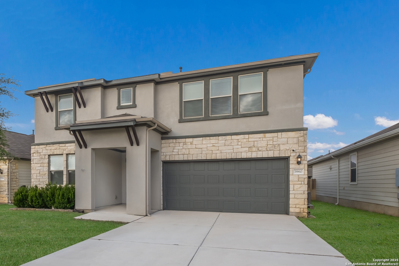 a front view of a house with a garden and garage