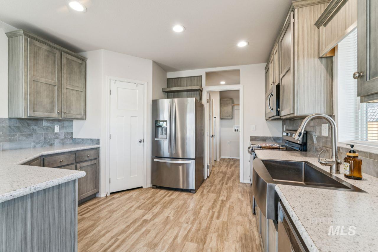 2750 Alden Road, Unit 2 Fruitland, ID 83619 - Photo 4 of 24 Kitchen with backsplash, stainless steel appliances, light stone countertops, light wood-style floors, and recessed lighting