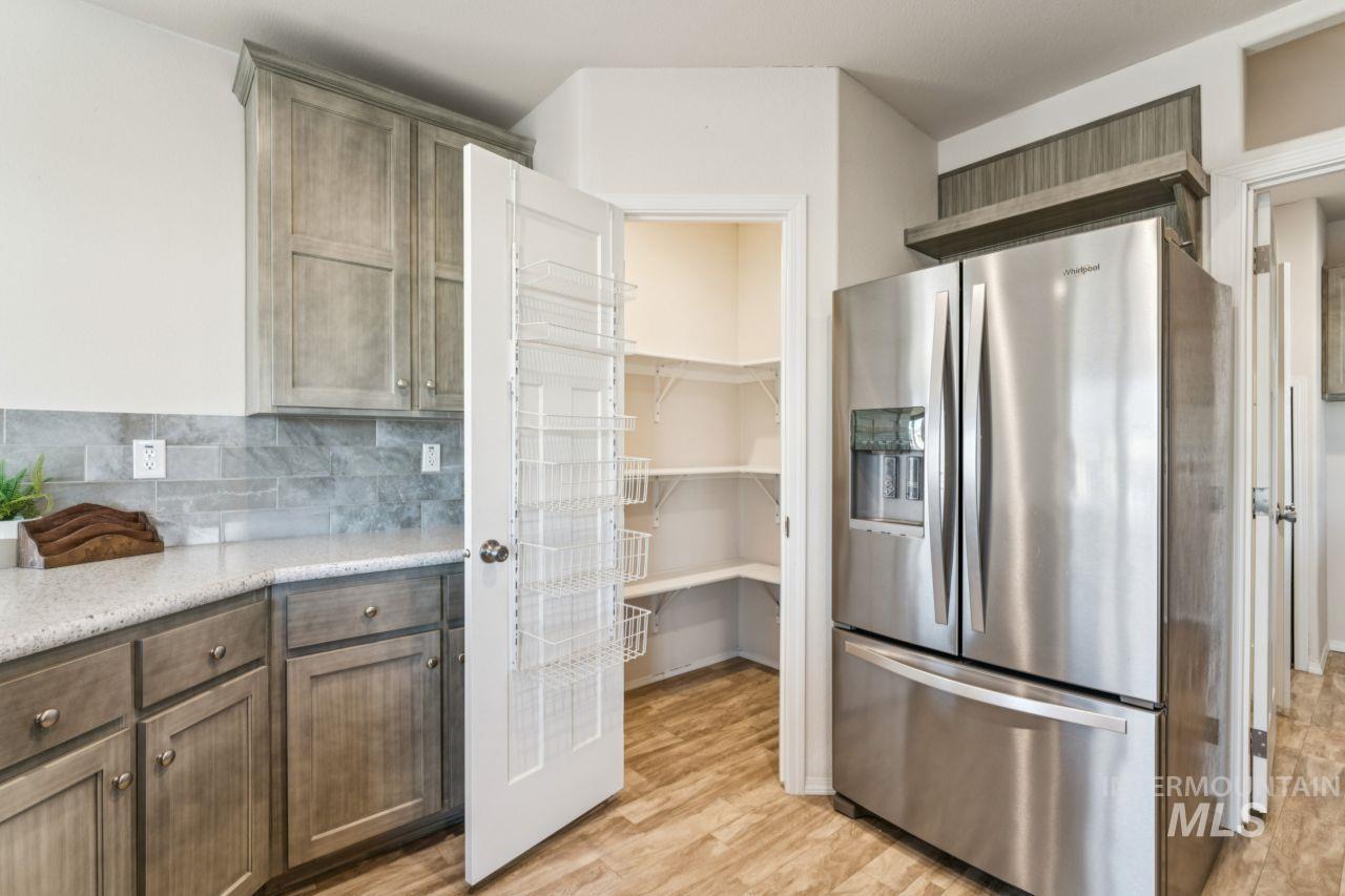 2750 Alden Road, Unit 2 Fruitland, ID 83619 - Photo 6 of 24 Kitchen featuring stainless steel refrigerator with ice dispenser, backsplash, light wood-style floors, and light stone countertops