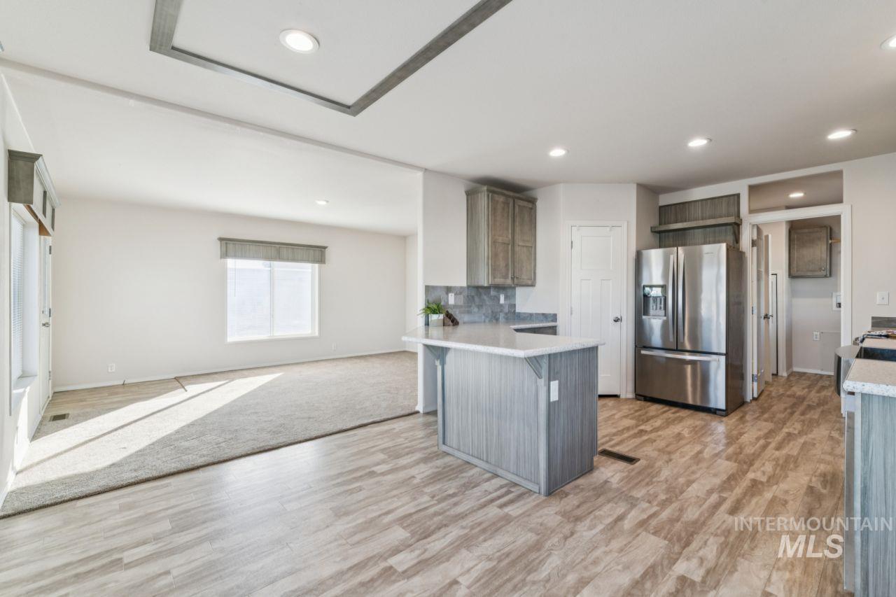2750 Alden Road, Unit 2 Fruitland, ID 83619 - Photo 24 of 24 Kitchen featuring stainless steel fridge, open floor plan, a peninsula, light wood finished floors, and a kitchen breakfast bar