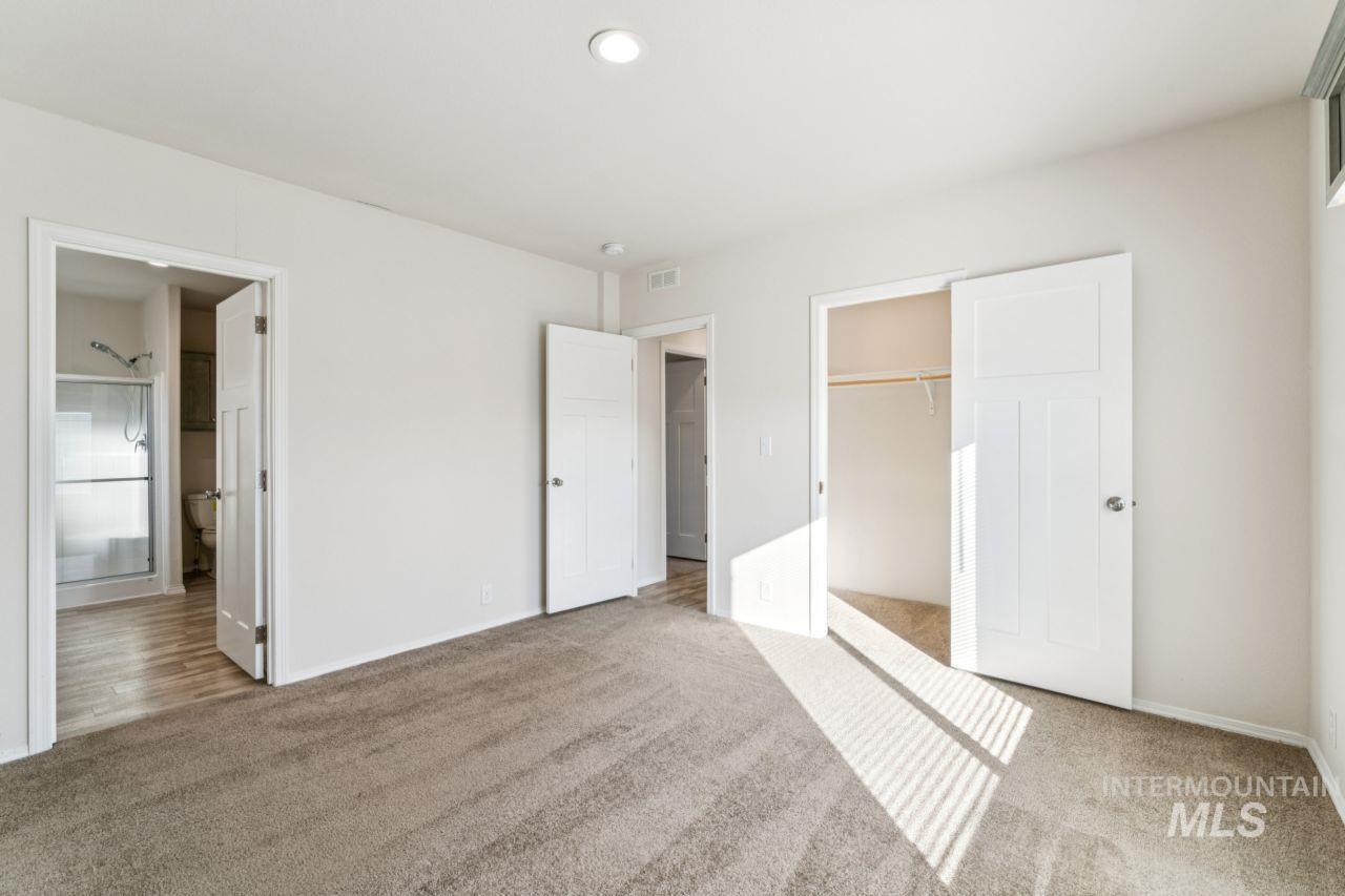 2750 Alden Road, Unit 2 Fruitland, ID 83619 - Photo 7 of 24 Unfurnished bedroom with a closet, light colored carpet, and ensuite bath