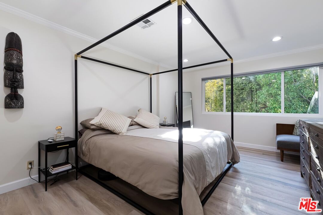 4221 Vanetta Drive Studio City, CA 91604 - Photo 22 of 41 a bedroom with a bed a table and large windows