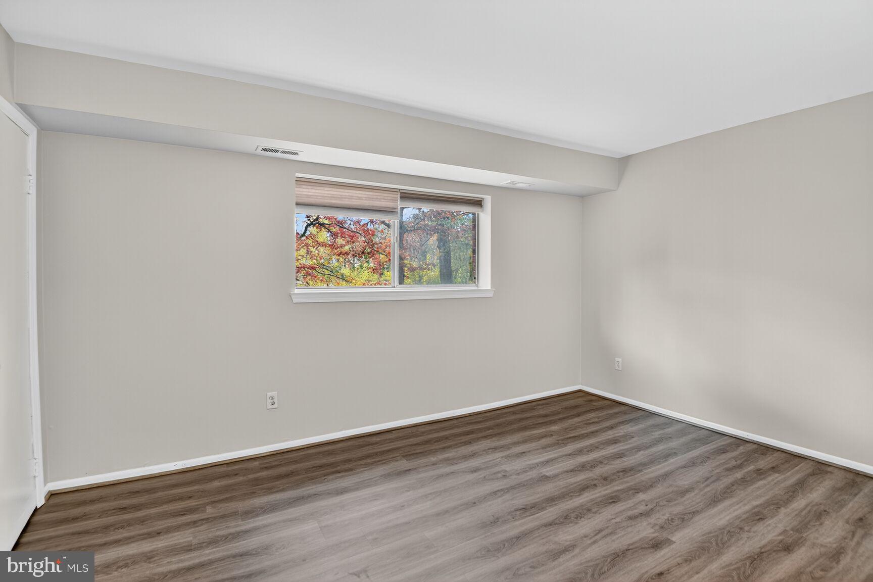 7505 Riverdale Road, Unit 2039 Hyattsville, MD 20784 - Photo 11 of 15 a view of an empty room with wooden floor and a window