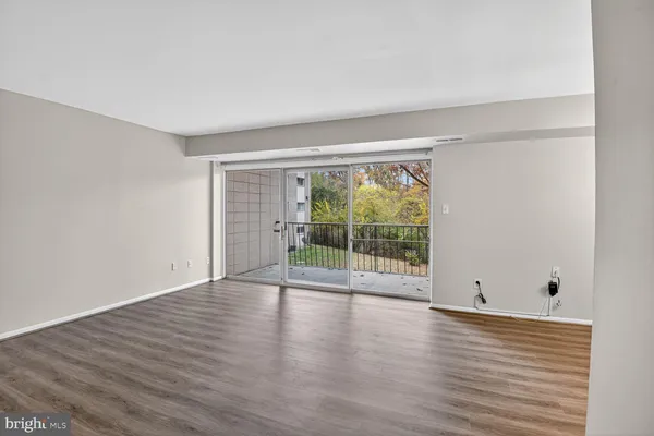 a view of room with window and wooden floor