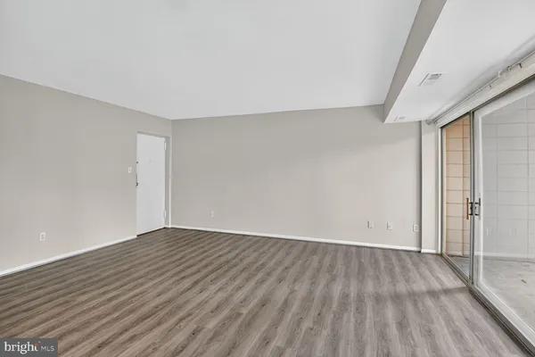 a view of an empty room with wooden floor