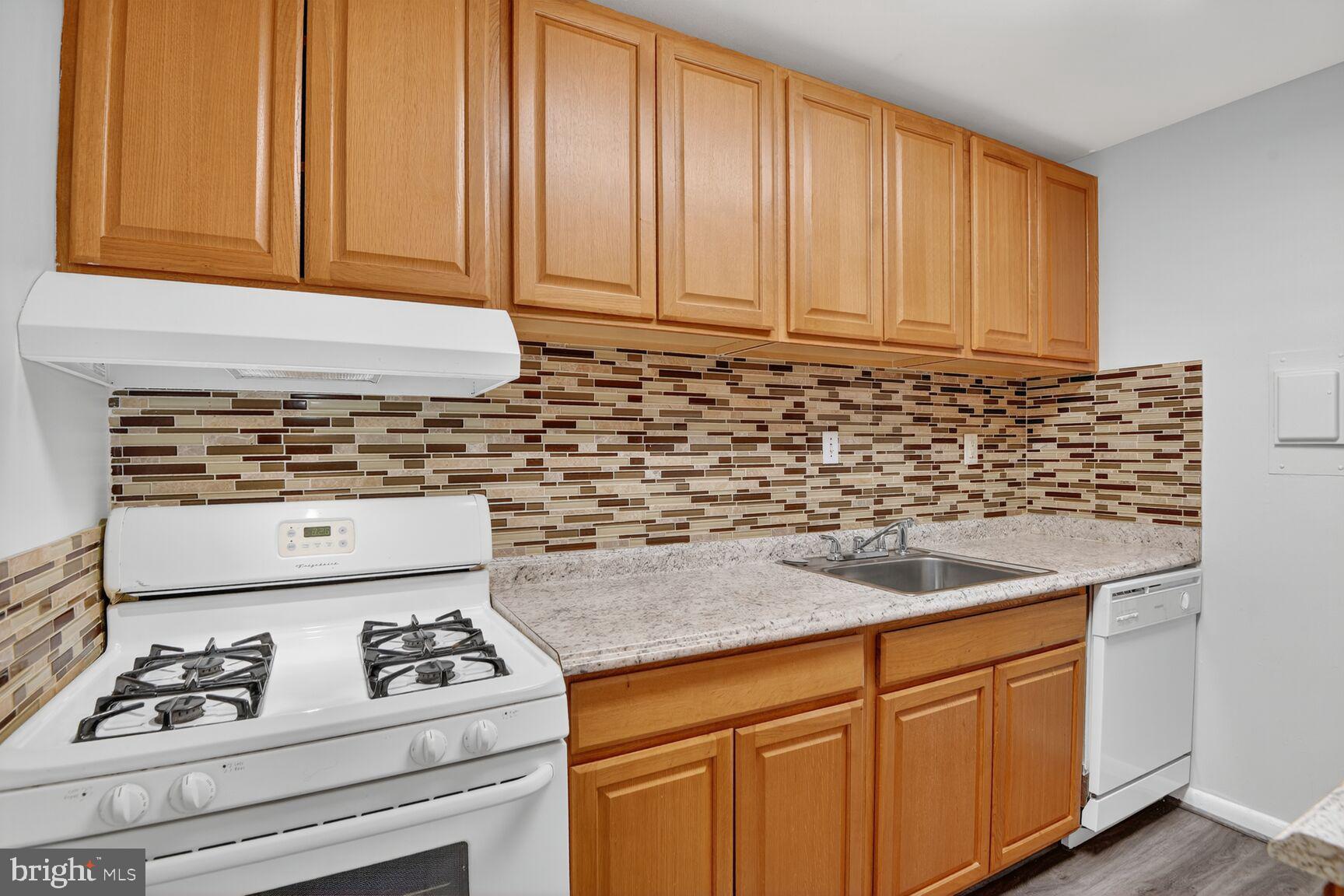 7505 Riverdale Road, Unit 2039 Hyattsville, MD 20784 - Photo 8 of 15 a kitchen with granite countertop cabinets and white appliances