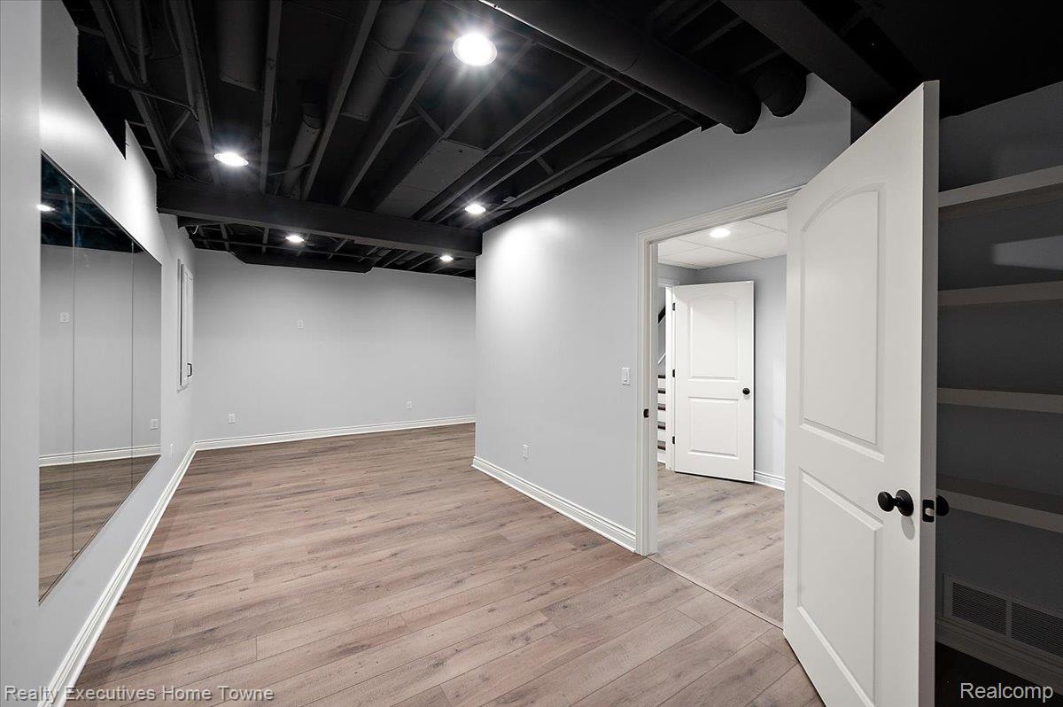 2919 North Addison Circle Rochester, MI 48306 - Photo 64 of 69 Recessed lighting, exposed black ceiling, wood-finish flooring, white paneled doors, and built-in shelving