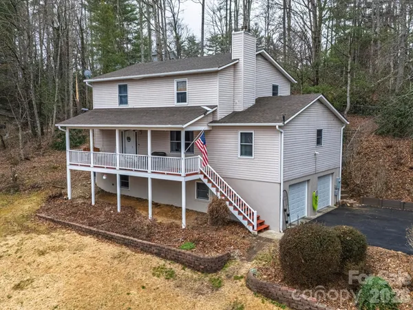 a view of a white house with large windows and a small yard