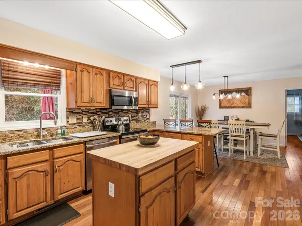 a kitchen with a sink stove cabinets and wooden floor