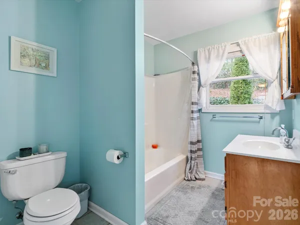 a bathroom with a toilet a sink and a window