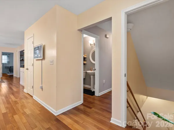 a view of a hallway with wooden floor and staircase
