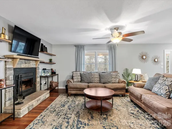 a living room with furniture a fireplace and a flat screen tv