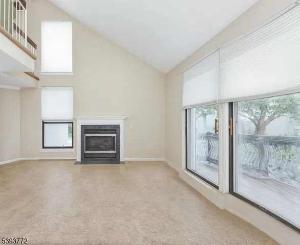 a view of an empty room with a fireplace and a window