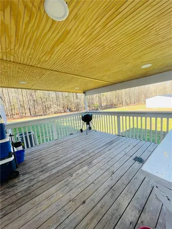 a view of a swimming pool with a yard and large tree