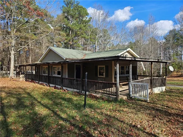 a view of house with a yard and wooden fence