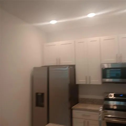 a kitchen with a refrigerator and a stove top oven
