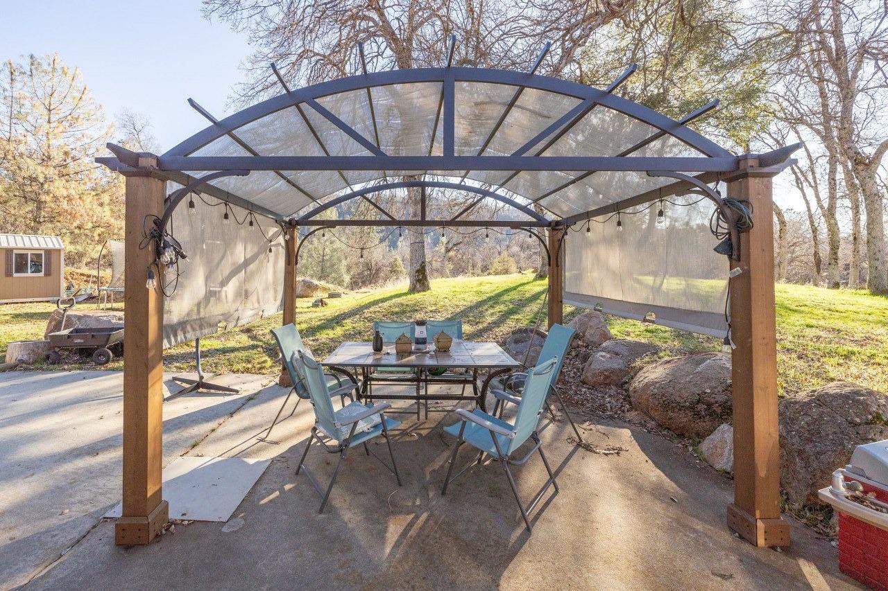 36820 Mudge Ranch Road Coarsegold, CA 93614 - Photo 5 of 75 a view of porch with a table and chairs under an umbrella