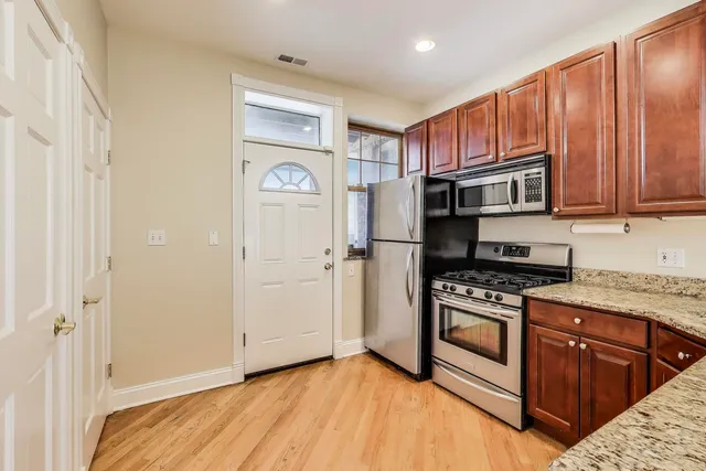 a kitchen with stainless steel appliances granite countertop a refrigerator and a stove top oven