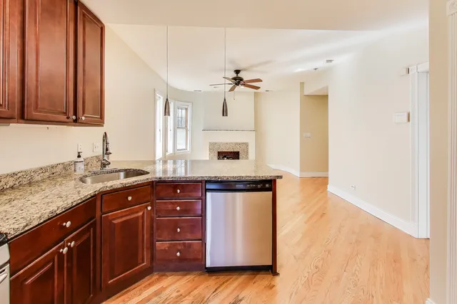 a kitchen with granite countertop a sink cabinets and stainless steel appliances