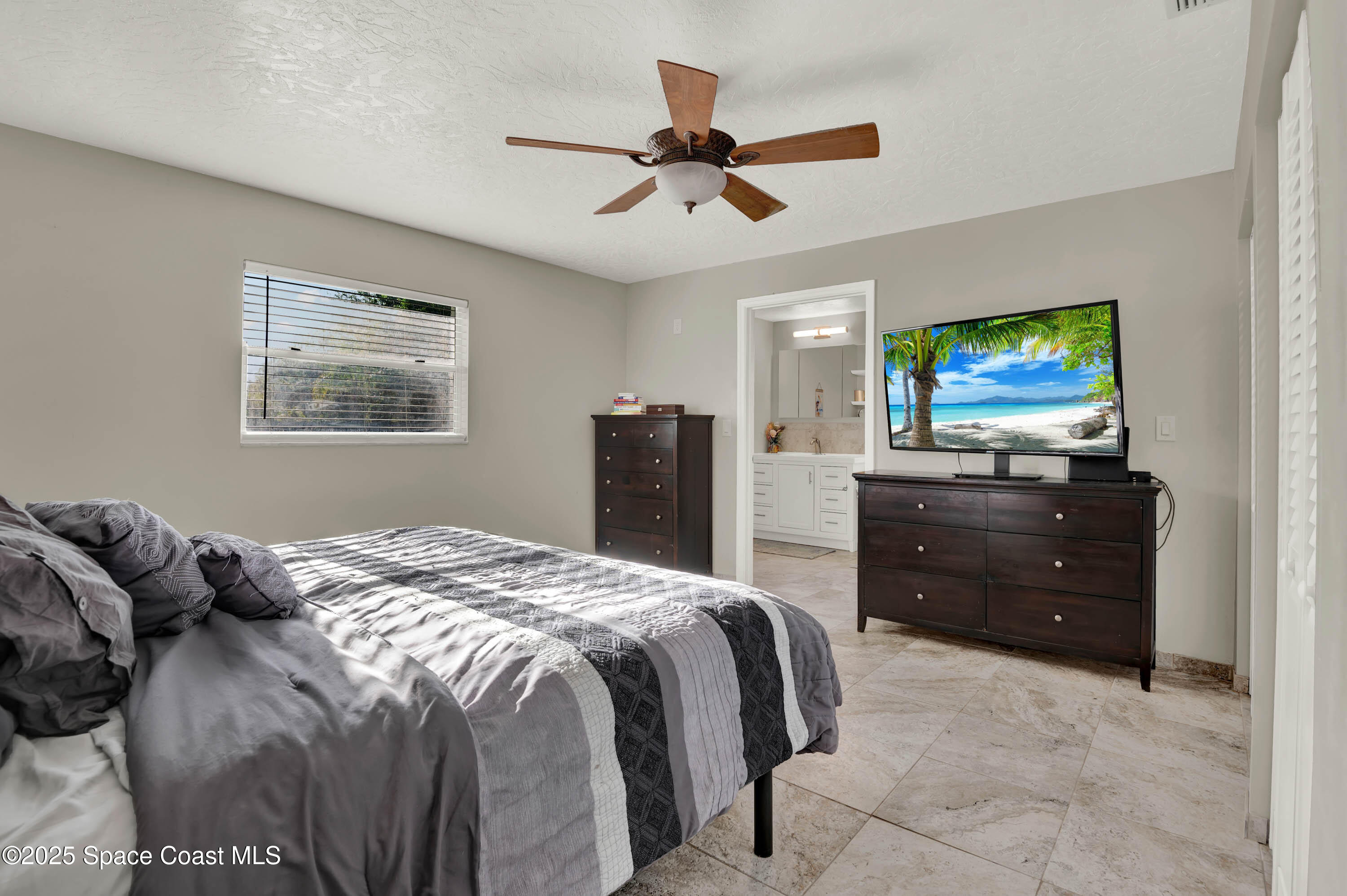 930 Miller Lane Melbourne, FL 32934 - Photo 14 of 40 a bedroom with a bed and a television