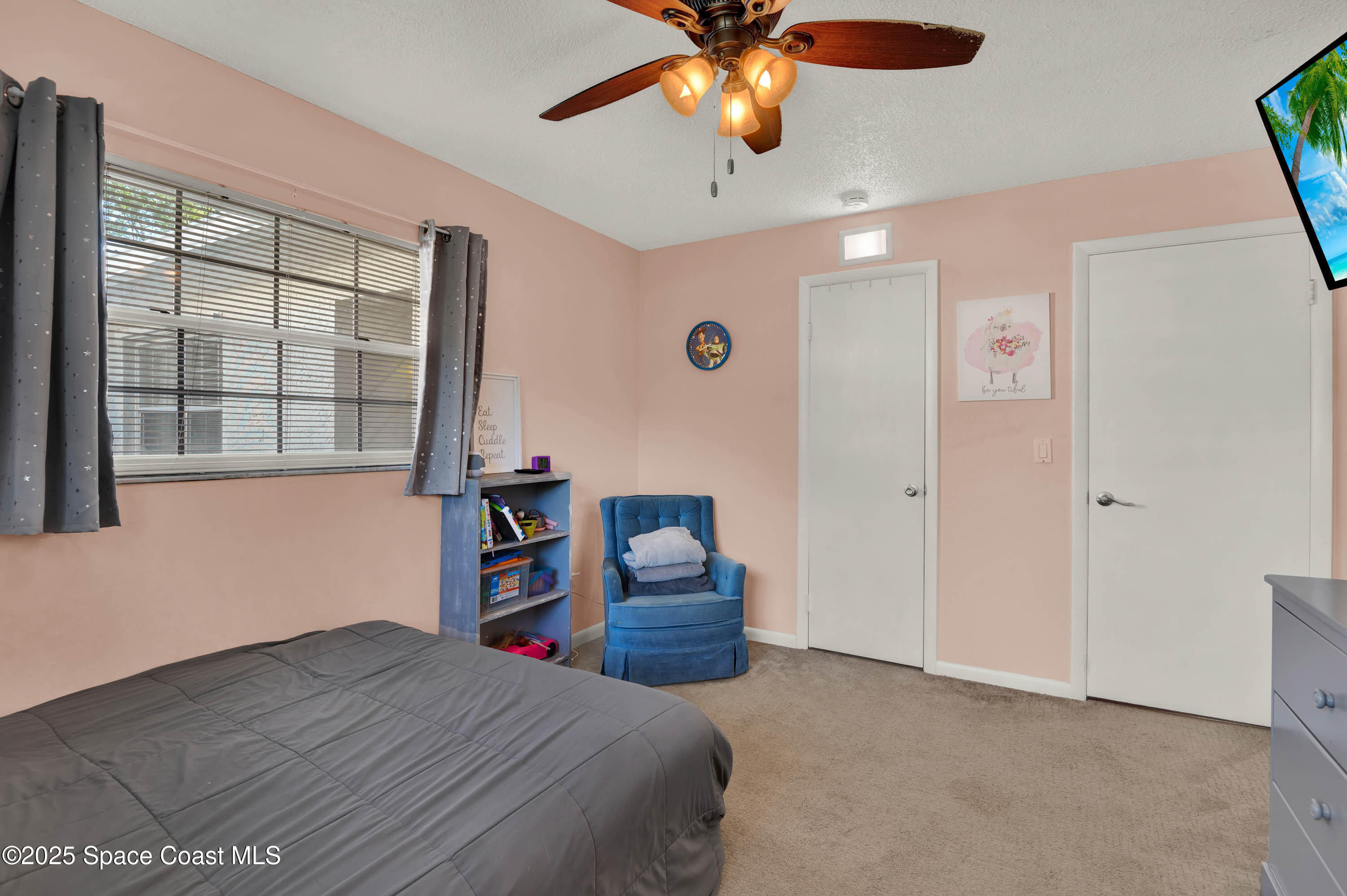 930 Miller Lane Melbourne, FL 32934 - Photo 20 of 40 a bedroom with a bed and a chandelier