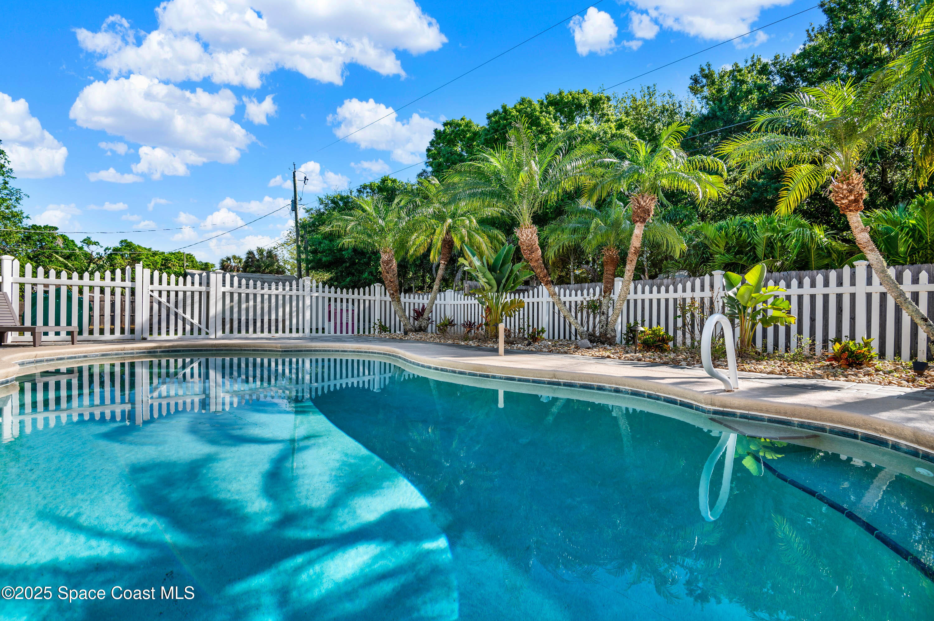930 Miller Lane Melbourne, FL 32934 - Photo 29 of 40 a view of a swimming pool with a patio and a garden