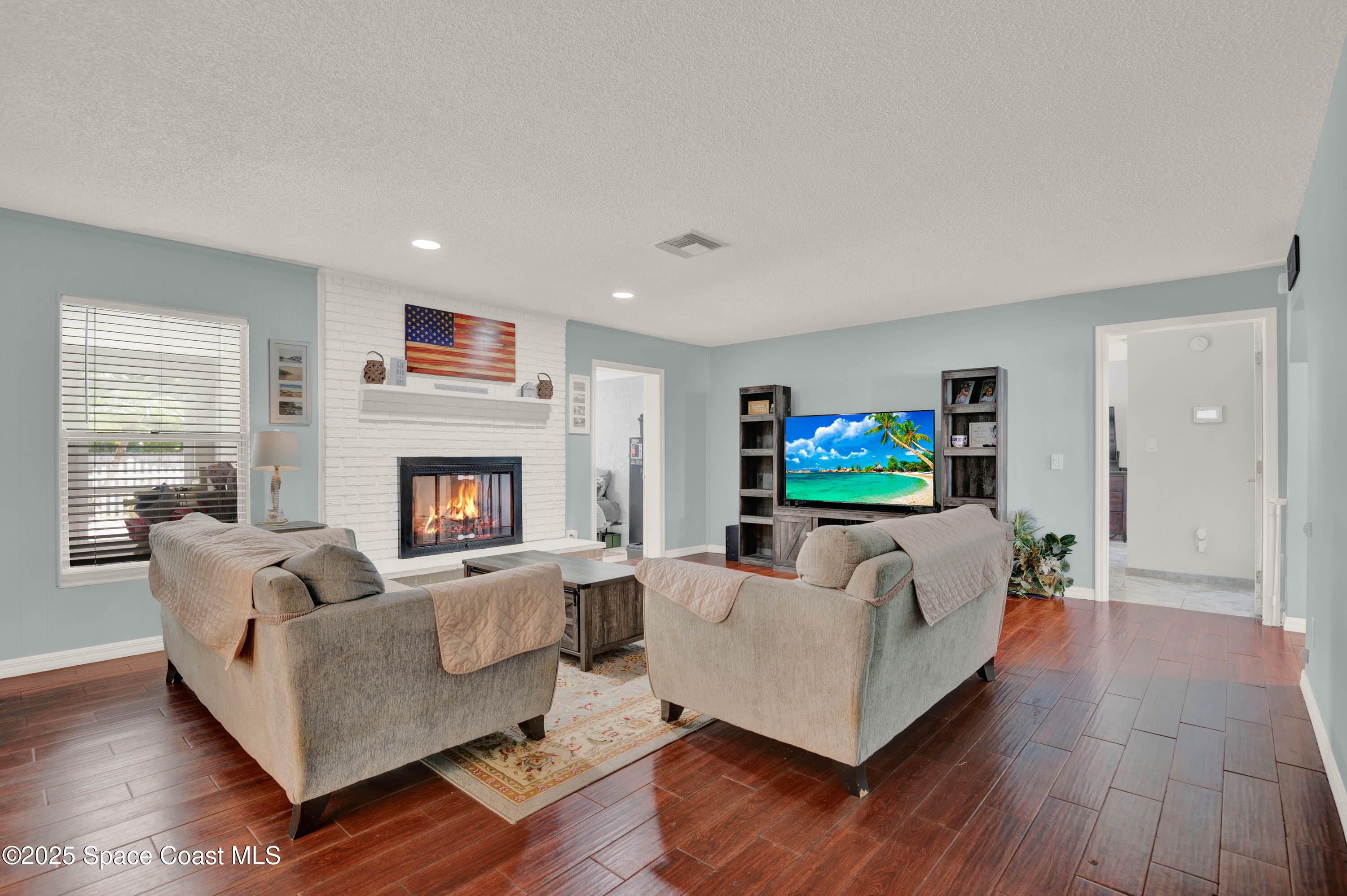 930 Miller Lane Melbourne, FL 32934 - Photo 8 of 40 a living room with furniture and a fireplace