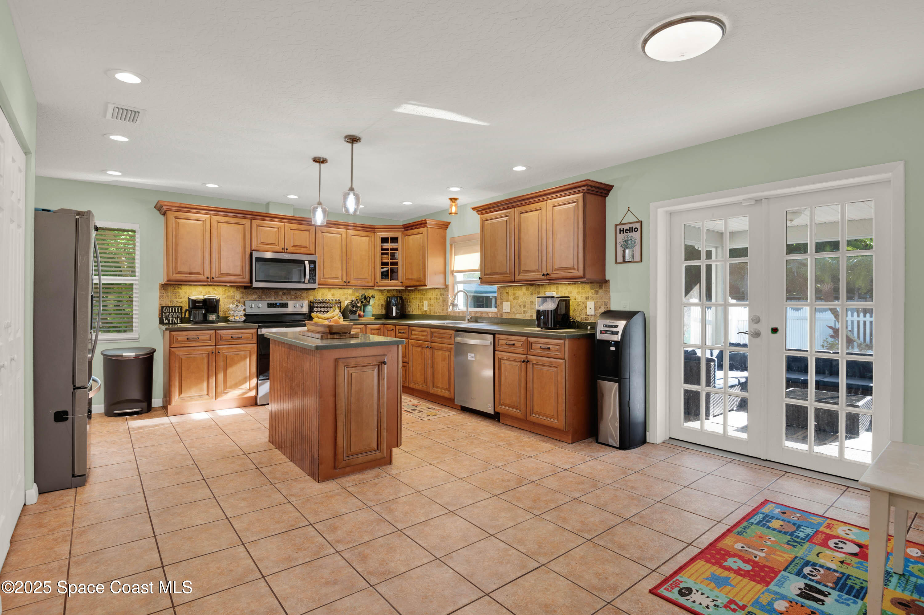 930 Miller Lane Melbourne, FL 32934 - Photo 10 of 40 a kitchen with stainless steel appliances granite countertop a refrigerator a sink a stove top oven a dining table and chairs