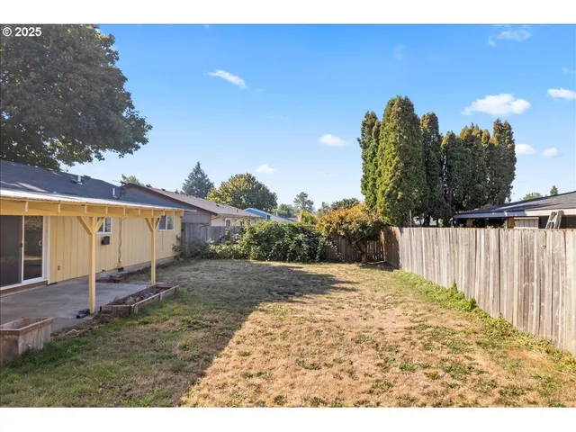 a backyard of a house with table and chairs
