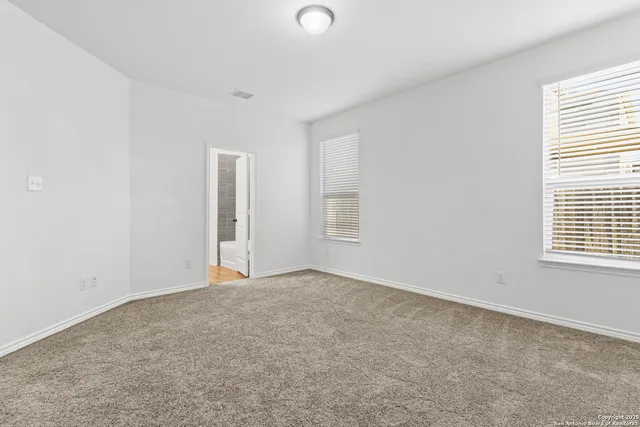 an empty room with windows and closet