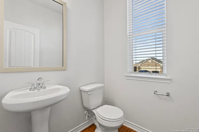 a bathroom with a sink a toilet and mirror