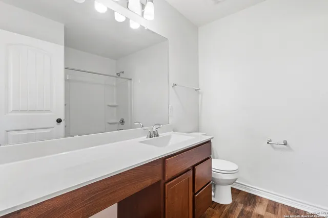 a bathroom with a sink a toilet and shower