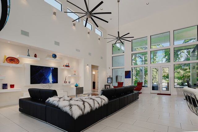 a living room with furniture large window and a flat screen tv