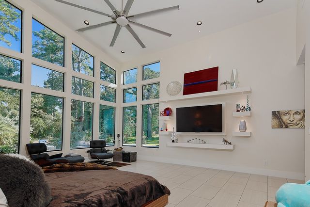 a living room with furniture large windows and a flat screen tv