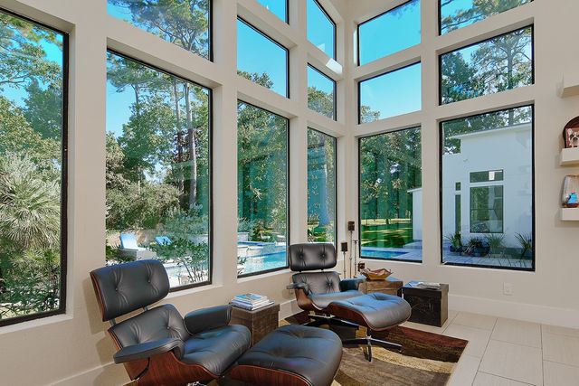 a living room with furniture and floor to ceiling windows