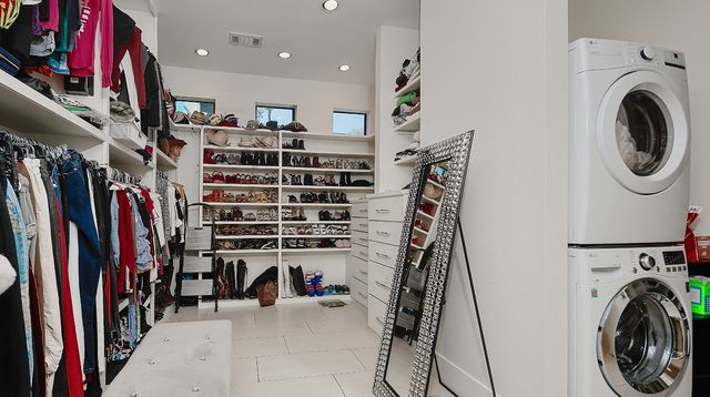 a view of walk in closet with clothes and shoes