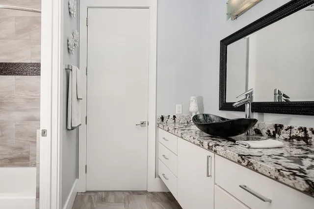 a bathroom with a granite countertop sink and a mirror