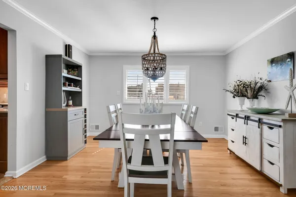 a kitchen with stainless steel appliances granite countertop a table chairs sink refrigerator and cabinets