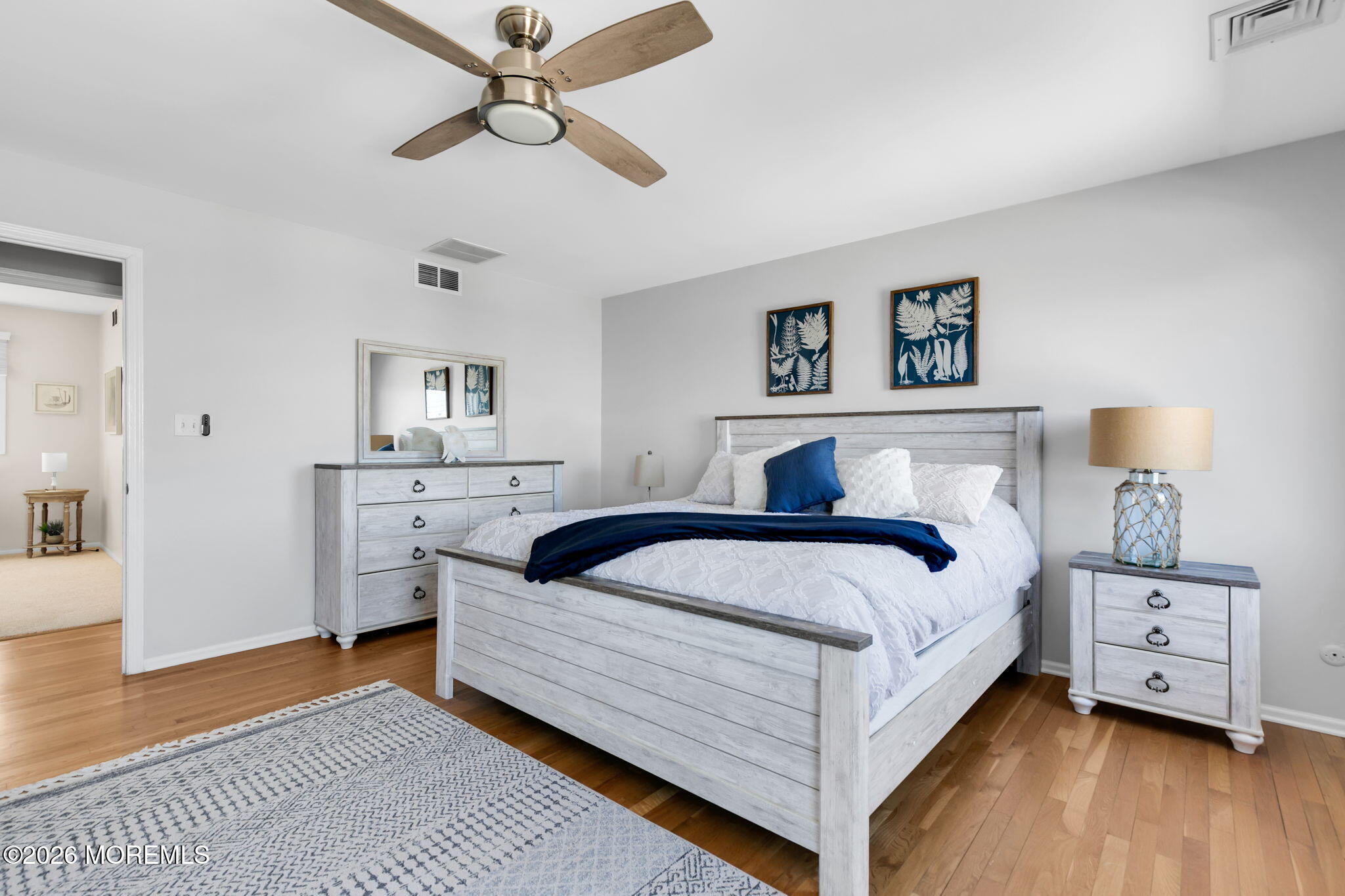 327 Tide Pond Road Mantoloking, NJ 08738 - Photo 26 of 45 a bedroom with a large bed and a chandelier